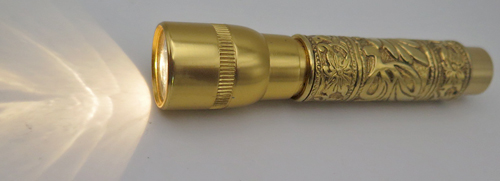ITEM #2479: GOLD PLATED FLASHLIGHT WITH VICTORIAN REPOUSSE WORKMANSHIP. Twist actuated to turn on/off. Light works. Uses AAA battery
