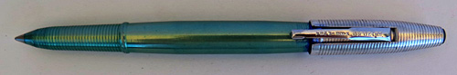 4583: REYNOLDS INTERNATIONAL BALLPOINT IN ANODIZED GREEN WITH ALUMINUM CAP WITH CIRCUMFERENTIAL GROVES. CAP COVER HAS MATCHING GREEN TIP. CAP REMOVES AND SNAPS ON OVER THE FRONT END OF THE PEN. COMES WITH PAPER INSTRUCTIONS AND GUARENTEE. CONTAINS CLEAR CELLOPHANE COVER AND AN ALUMINUM PEDISTOOL. ALL ITEMS FIT INSIDE AND ELABORATE CYLINDRICAL DISPLAY CASE IN OLIVE GREEN WITH REYNOLDS PEN LOGO STILL VISABLE