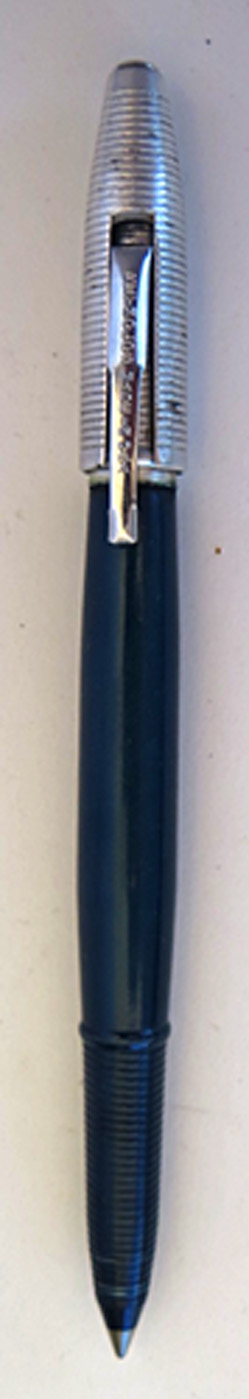 #4587: REYNOLDS INTERNATIONAL BALLPOINT IN DARK BLUE WITH ALUMINUM CAP WITH CIRCUMFERENTIAL GROVES. THE CAP REMOVES AND SNAPS ON OVER THE FRONT END OF THE PEN. ELABORATE DISPLAY CASE IN OLIVE GREEN. IT CONTAINS A VERY CLEAR CELLOPHANE COVER AND AN ALUMINUM BASE