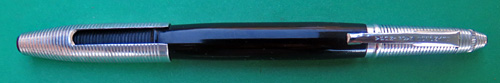 4593: REYNOLDS INTERNATIONAL BALLPOINT IN ANODIZED BLACK WITH RED JEWEL ON THE TIP OF THE CAP AND THE TOP OF THE CAP COVER, IN NEAR MINT CONDIDITION, NEVER USED. OF COURSE, THIS PEN DOES NOT WRITE BECAUSE THE FILLING SYSTEM IS DRIED OUT, THOUGH IT DID NOT WRITE WELL EVEN WHEN IT WAS NEW. THE INTERNATIONAL MODEL HAS A CAP/POINT COVER WHICH FITS OVER THE CAP OR THE POINT. THERE IS NO WEAR ON THE ANODIZING