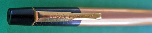 4596: REYNOLDS 400 BALLPOINT. SMOOTH GOLD ANODIZED ALUMINUM BARREL AND A BLACK CAP. THE FILLER TIP IS COVERED BY A SLIDING BALL PROTECTOR THAT CLICKS WHEN PULLED/PRESSED, WHICH IS AN INTEGERAL PART OF THE PEN. THIS PEN DOES NOT WORK AS THE FILLING UNIT IS DRIED OUT, BUT THE PEN DID NOT WORK WELL WHEN IT WAS NEW, EITHER.
