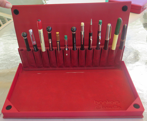 6274: BANKERS PEN STORAGE/DISPALY BOX WITH 14 SLOTS, IN RED. BOX INCLUDES 13 AUTOPOINT PENS/PENCILS