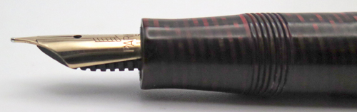 ITEM #6779: "George S. Parker VACUUM FILLER" (earlier than a vacumatic) IN LAMINATED BURGUNDY. LOCKDOWN FILLING SYSTEM WITH NO COROSION ON THE PLUNGER TUBE. STANDARD SIZE PEN WITH DOUBLE JEWEL. GOLD FILL TRIM. PARKER ARROW VAC NIB IN GOLD COLOR. NIB GRADE IS FINE. Made in USA.