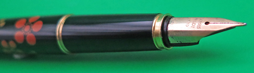 ITEM #6781: PILOT MAKIE FOUNTAIN PEN IN BLACK LACQUER WITH ORANGE & GOLD FLOWERS. IMPRINT IS "PILOT JAPAN". 14K NIBIN BROAD/MEDIUM (ON PARKER FACTORY NIB GRADER). DATE CODE ON NIB IS A597. SQUEEZE TYPE FILLING SYSTEM. 