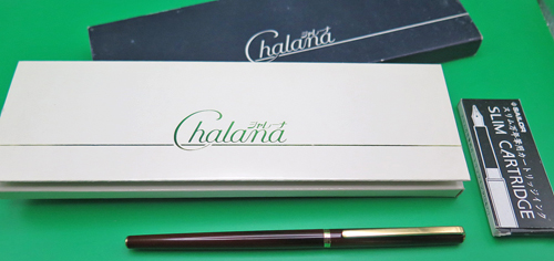 ITEM #6836: SAILOR ULTRA SLIM CHALANA FOUNTAIN PEN IN BROWN LACQUER STRIPE WITH NAVY SECTION. BLACK DOUBLE JEWEL. CAP JEWEL READS "JAPAN". 14K "SAILOR" NIB IN FINE. GOLD PLATED TRIM. NEW OLD STOCK IN BOX. Part #11-0520