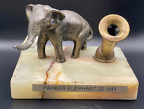 ITEM #6851: PARKER LIGHT COLORED ONYX MARBLE DESK BASE WITH BRASS ELEPHANT. BRASS PEN HOLDER. DIMENSION OF DESK BASE IS 5.5"x 3.5" x 4.33 INCHES. Trunk has been broken and glued on.